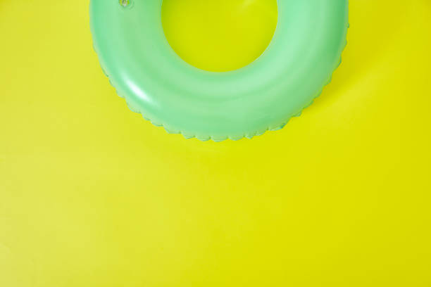 grüner aufblasbarer ring auf gelbem hintergrund. raum für text. - inner tube inflatable isolated toy stock-fotos und bilder