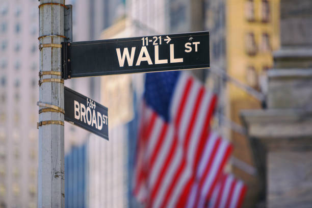 wall street signe à new york avec des drapeaux américains en arrière-plan - global financial crisis photos photos et images de collection