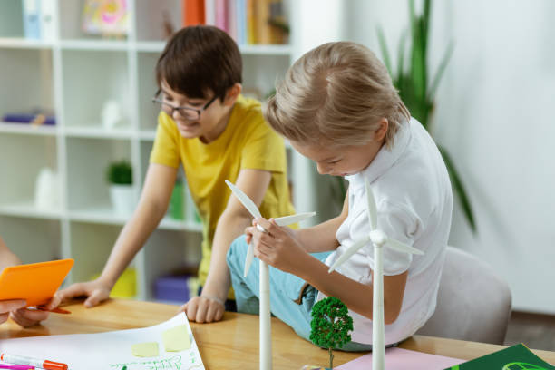 istock Curious blonde boy observing mechanism of plastic windmill 1148332770