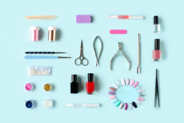 Photo of Set of various manicure and pedicure tools and accessories on light blue background. Top view.