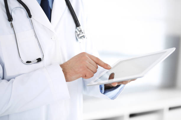 istock Doctor man using tablet computer for network research or virtual disease treatment, hands close-up. Perfect medical service in clinic. Modern  medicine, medic data and healthcare concepts 1148337142