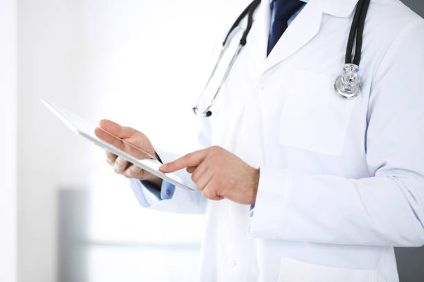 istock Doctor man using tablet computer for network research or virtual disease treatment, hands close-up. Perfect medical service in clinic. Modern  medicine, medic data and healthcare concepts 1148337145