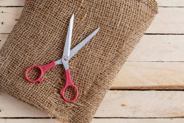 istock vintage scissors and canvas on wooden background. top view 1148349054