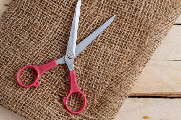 istock vintage scissors and canvas on wooden background. top view 1148349059