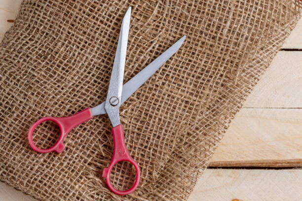 istock vintage scissors and canvas on wooden background. top view 1148349060