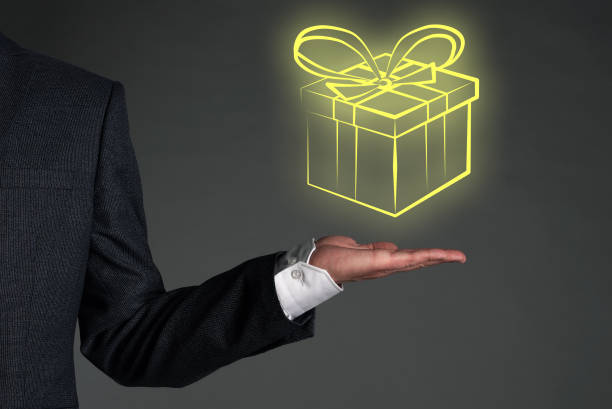 Gift. Gift box prize in a businessman hands on a gray background. Winner concept. gifts for boss stock pictures, royalty-free photos & images