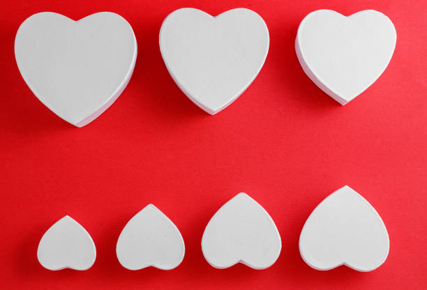 istock white heart-shaped cardboard boxes on red background 1148350715