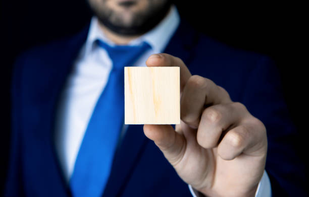 istock Businessman holding wooden cube in his hand 1148355237