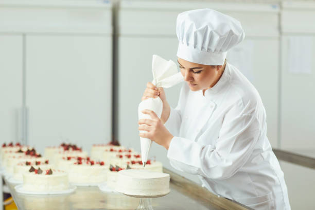 istock Confectioner decorating cake in pastry shop. 1148355450