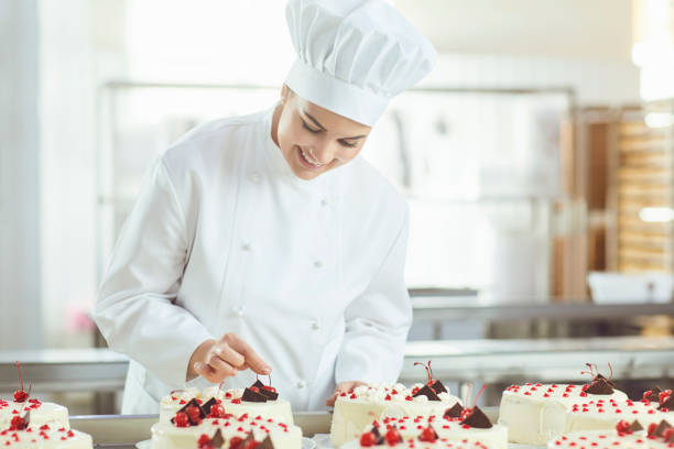 istock Confectioner is holding a cake in her hand in the bakery. 1148355451