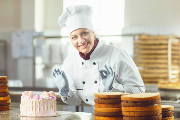 istock Confectioner with pastry cake in his hand at the bakery. 1148355456