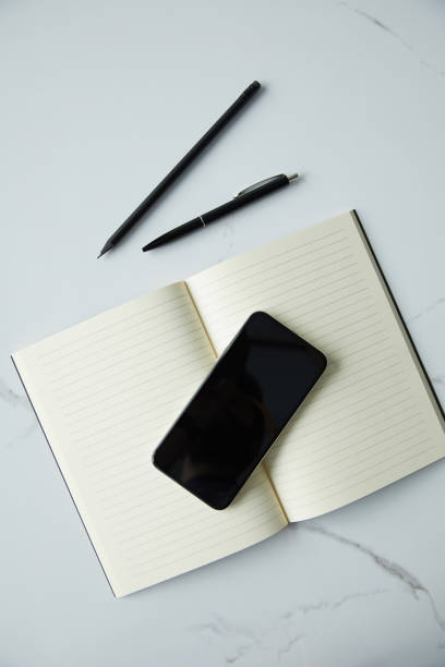 istock top view of smartphone with blank screen, notebook, pen and pencil on white marble surface 1148364002