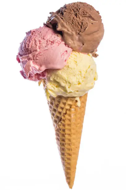 Photo of front view of real edible ice cream cone with 3 different scoops of ice cream (vanilla, chocolate, strawberry) isolated on white background