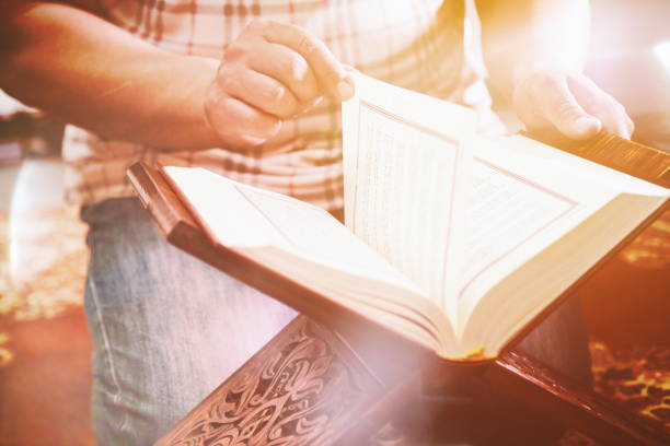 istock Midsection Of Man Reading Koran In Mosque 1148367364