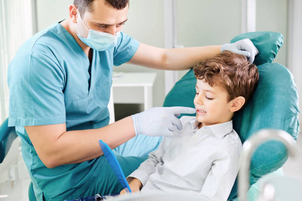 istock Boy child and dentist are checking teeth in the mirror. 1148376644