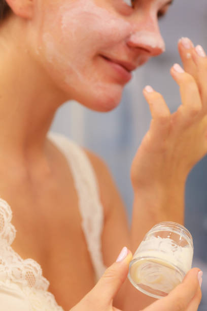 istock Woman applying mask cream on face in bathroom 1148379248
