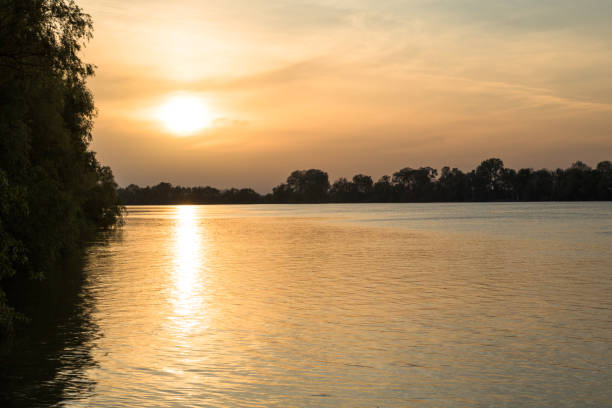 istock orange sunset through the clouds on the river 1148379414