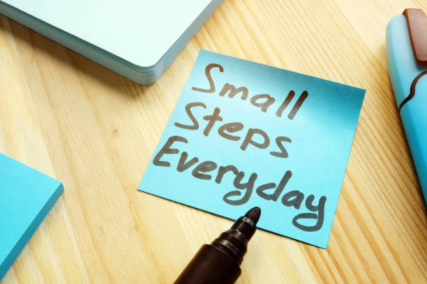 istock Handwritten quote Small steps everyday on table. Motivation concept. 1148379464
