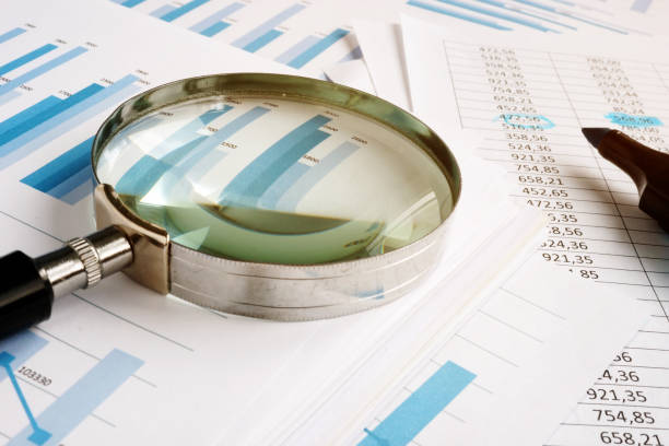 istock Magnifying glass for audit and stack of business reports. 1148379472