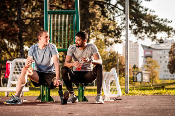 istock Friends resting during exercise in a city park gym 1148381906