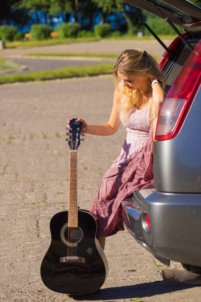 istock Hippie woman with guitar in van car 1148383356