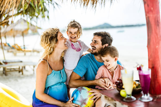 istock Happy parents having fun with their small kids in a beach bar. 1148383418