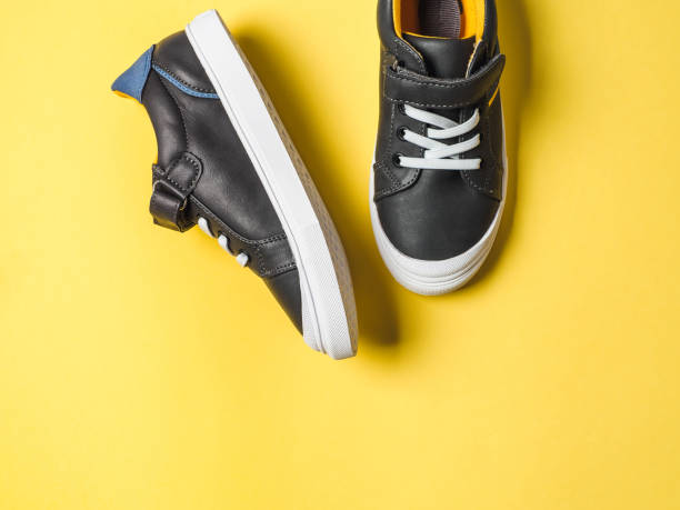 istock Gray and yellow sneakers on yellow background 1148388005