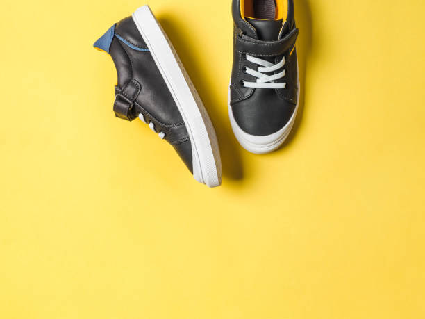 istock Gray and yellow sneakers on yellow background 1148388014