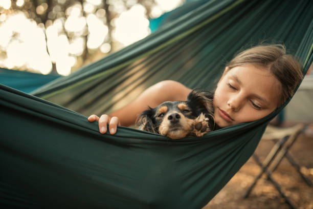 istock Girl relaxing in hammock with her dog 1148388169
