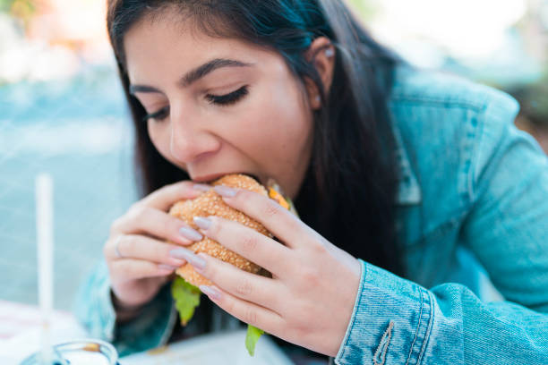 istock Girl Eating a Hamburger 1148394132