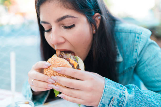 istock Girl Eating a Hamburger 1148394138