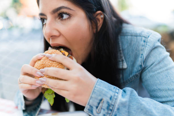 istock Girl Eating a Hamburger 1148394139