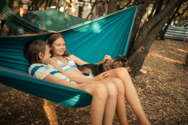 istock Children relaxing in hammock with dog 1148397611