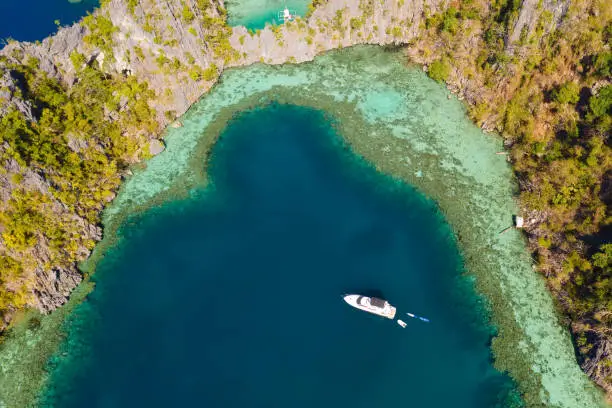 Photo of Boat in the azure lagoon.Lagoon with turquoise water surrounded by cliffs
