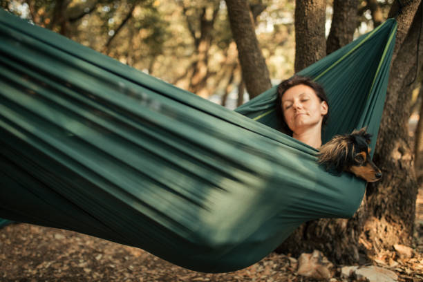 istock Woman relaxing in hammock with her dog 1148402412