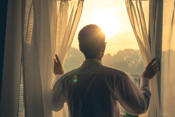 istock Good morning,Man hand open curtain 1148405749