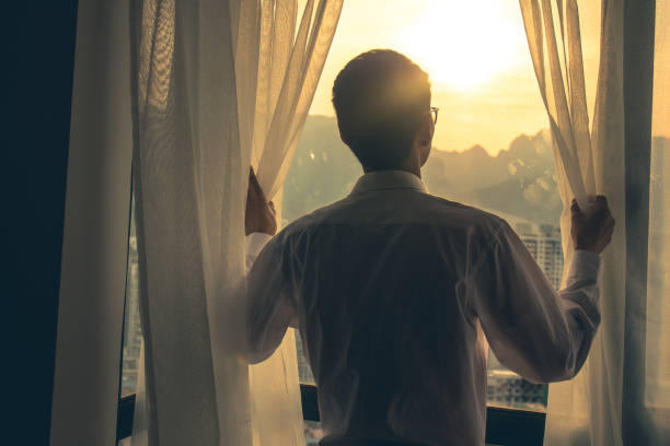 istock Good morning,Man hand open curtain 1148405759