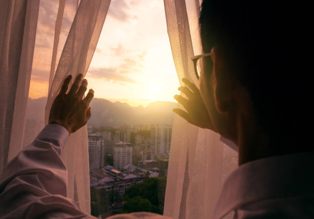 istock Morning sunlight,Man hand open curtain 1148405783