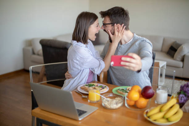 istock Young couple with vegan breakfast in dining room and computer. 1148406336