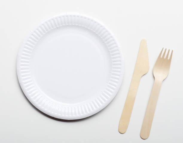 istock Wooden single use kitchenware and paper plate on white background closeup. Top view 1148410538