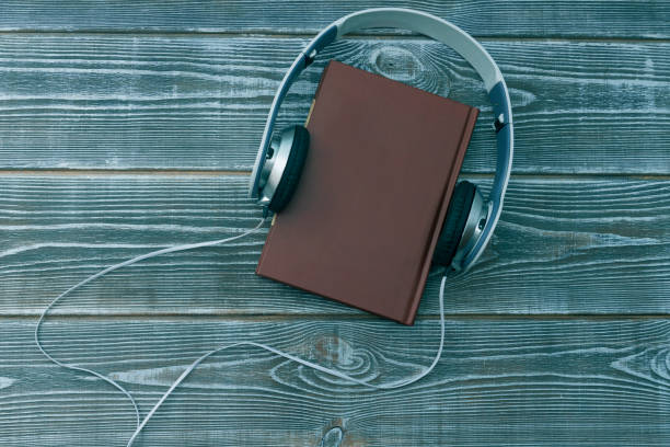 istock book, headphones on wooden background. 1148416664