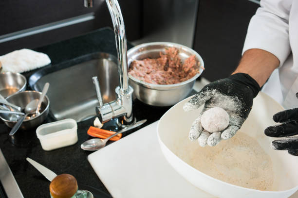 Latin male chef aged between 25-35 years is cooking a traditional meal in the kitchen