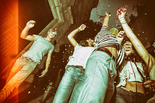 Megaparty: friends party wild in the streets, with fireworks and confetti