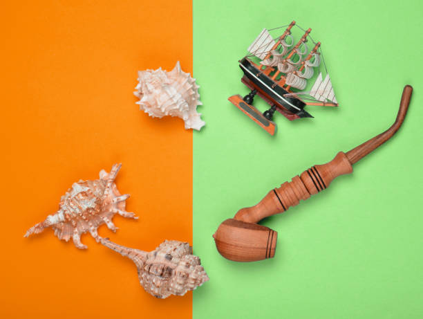 istock Decorative ship, seashells, chicken pipe on a colored pastel background. Captain shipwreck.  Summer Beach Concept. Top view, minimalism 1148421438