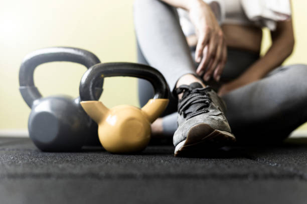 Girl resting after hard workout at the gym Fit woman taking a break from working out in gym. running shoes on floor stock pictures, royalty-free photos & images