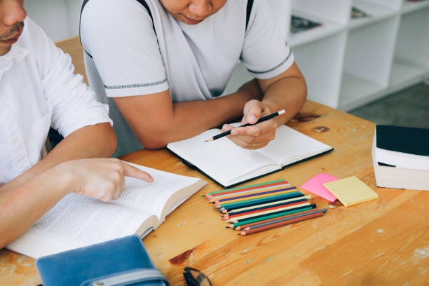 istock Asian student study with books preparing to exam in library. 1148423842