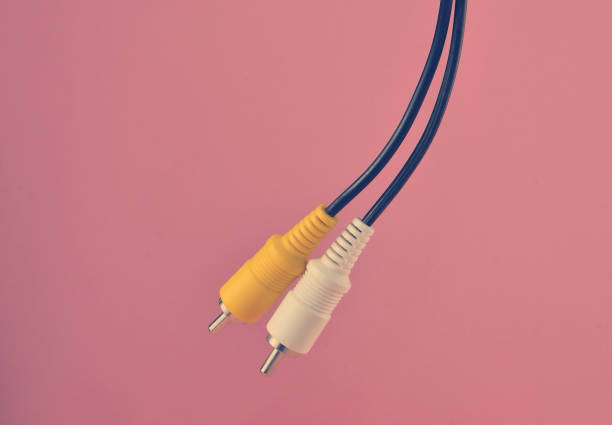 istock RCA yellow white audio/video cable on pink background. 1148424133