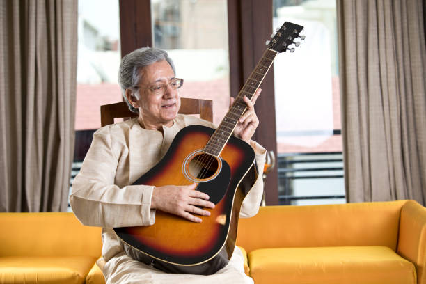 istock Senior man playing guitar at home 1148424185