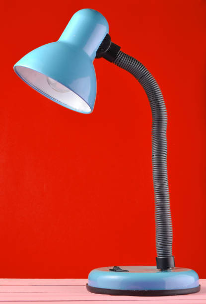 istock Table lamp on a table isolated against red wall background 1148424222