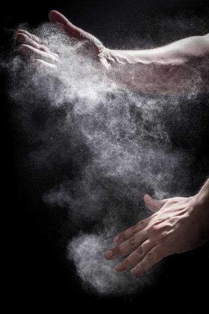 Hands Clapping Together with Dust Moody, Shadowy High-Speed Photo of a Caucasian Man's Hands Clapping Together in an Explosion of Dust and Powder - with a Black Background sports chalk stock pictures, royalty-free photos & images